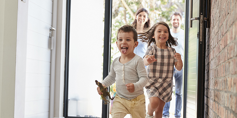 Excited Children Arriving Home With Parents
